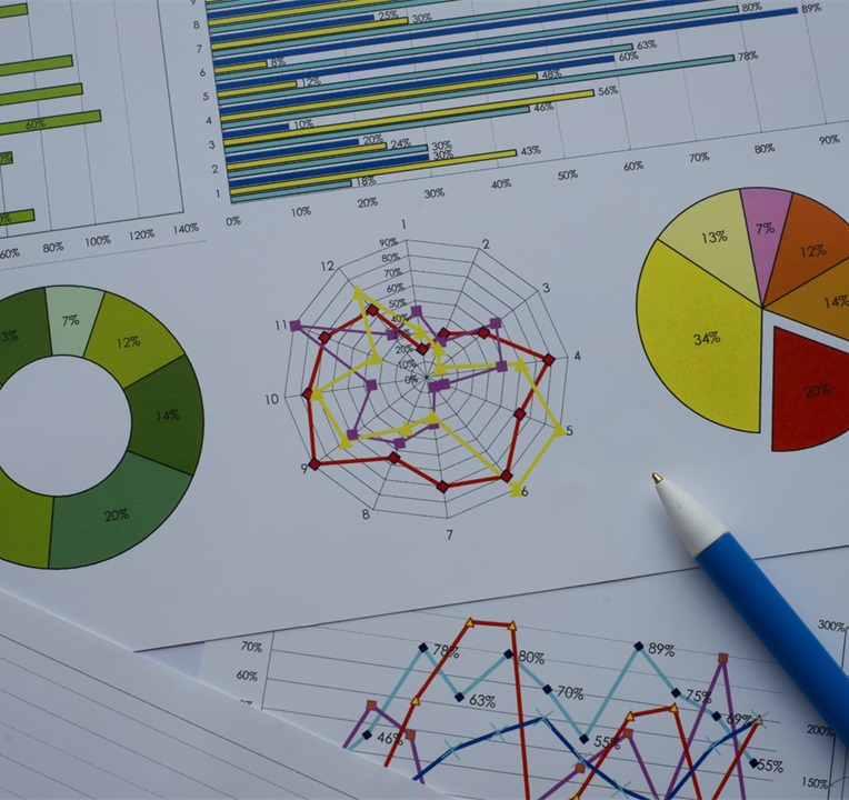 Examples of Excel charts and graphs on printed paper, including pie charts and radar charts.